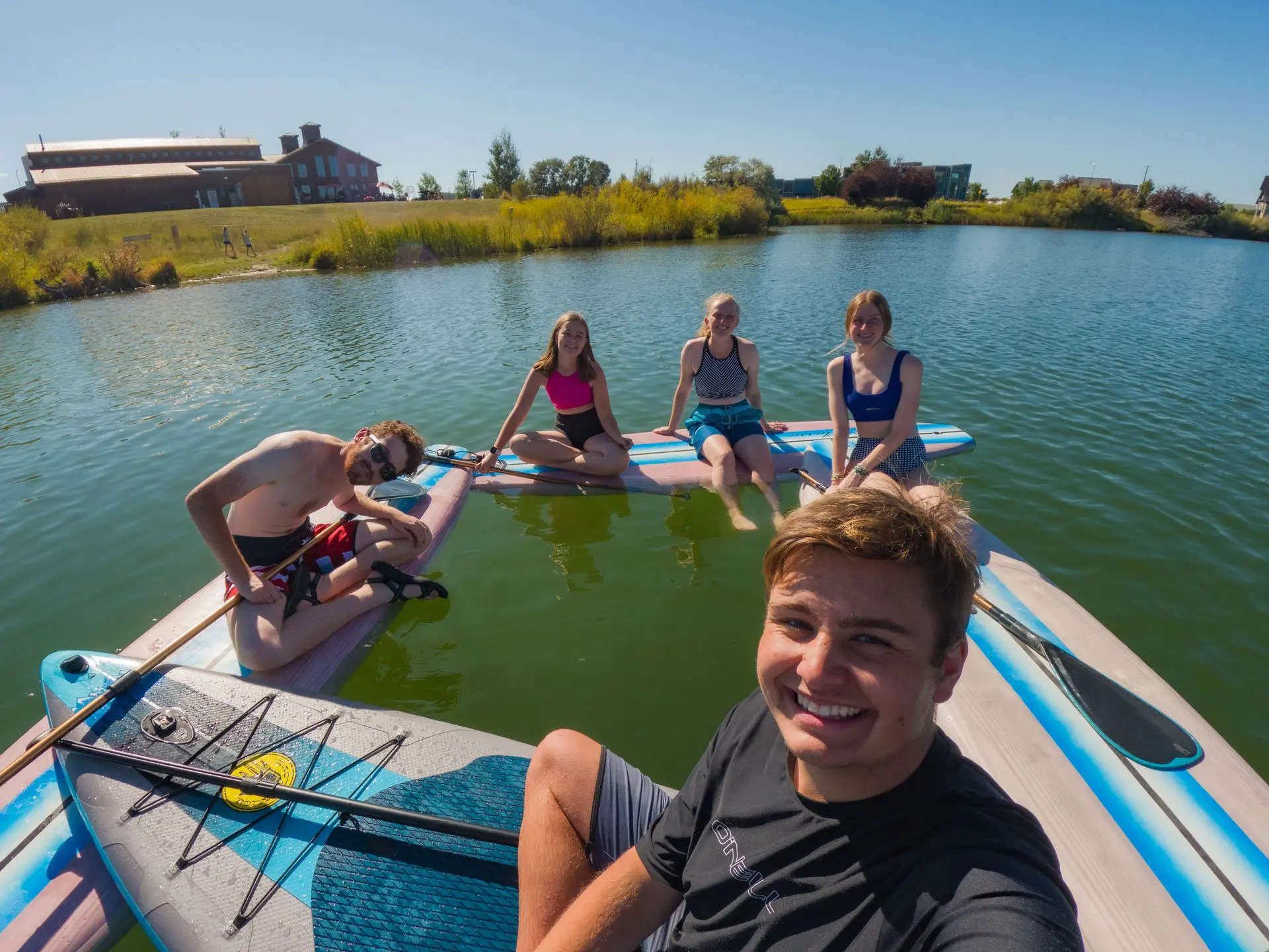 jacob hofer and makenna howard on paddle boards at the beach